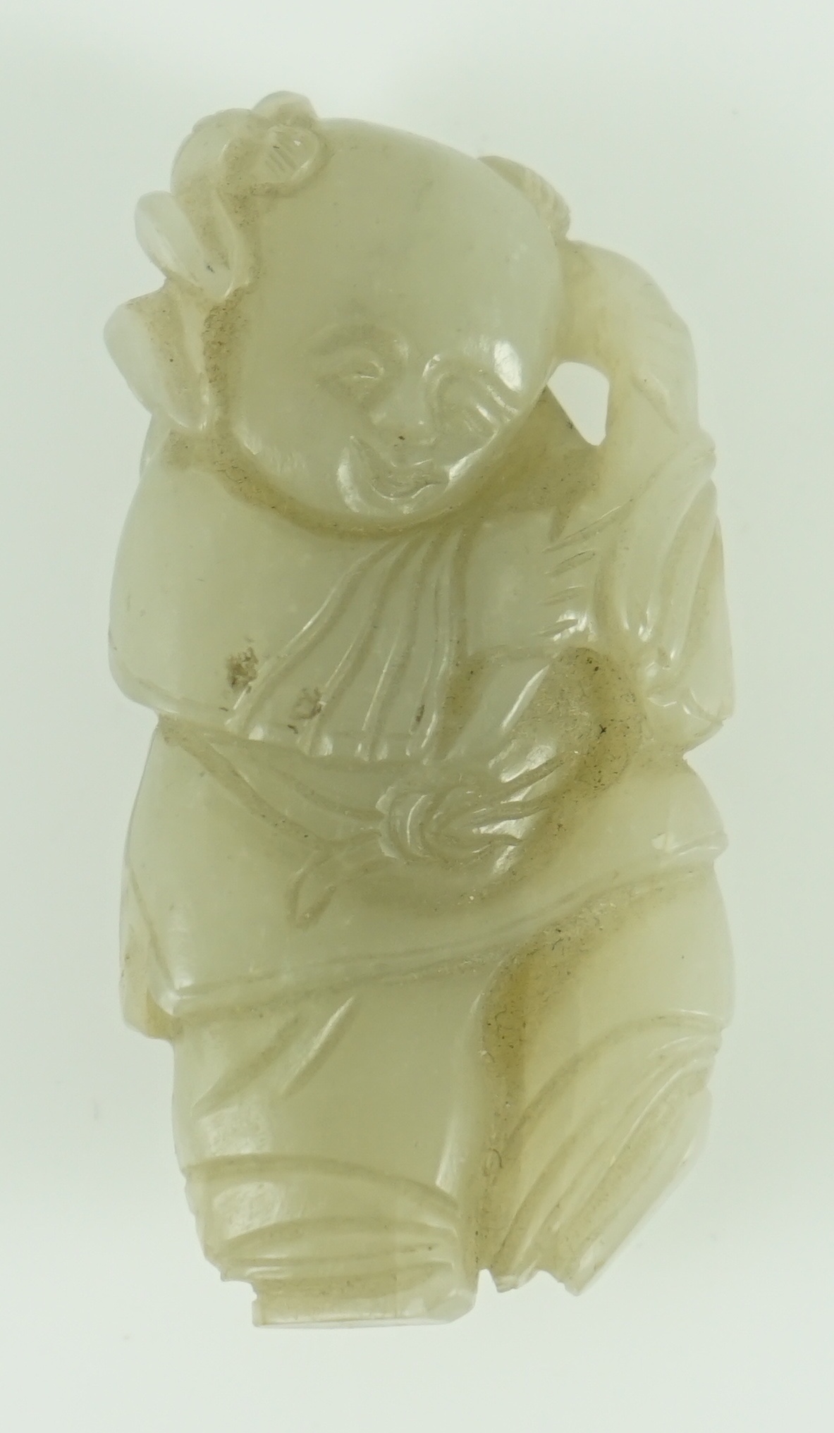 A Chinese celadon jade figure of a boy holding a lotus sprig, 19th century 5.2 cm high